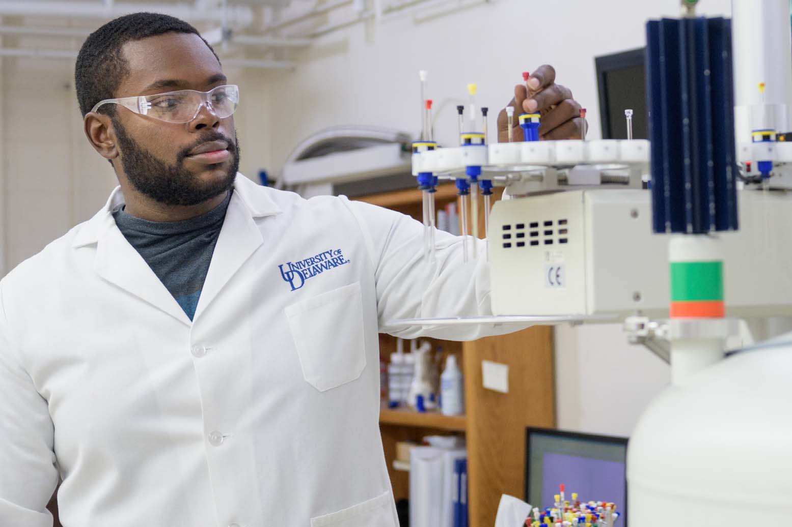 Graduate student works with test tubes in a lab.
